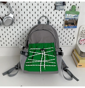 Macro-opname van de grijze en groene schoolrugzak met trekkoord en mesh zijvak voor kinderen