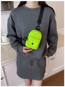 Close-up of fluorescent green waterproof nylon mini crossbody bag with black buckles