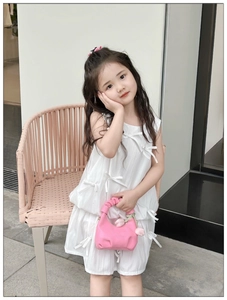 Pink pleated mini handbag with a tulip pendant held by a child in a white dress