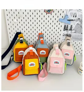 Detailed view of five color-block kids crossbody bags with mountain logo on pegboard background