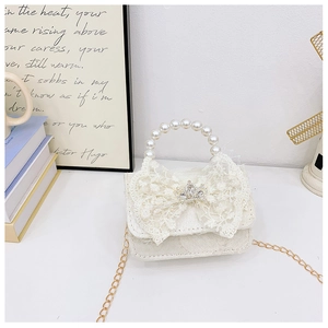 Gros plan du sac en dentelle blanche pour filles avec poignée en perles et couronne