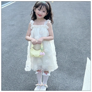 Detail of a white girl's dress featuring floral texture and soft ruffled shoulder straps
