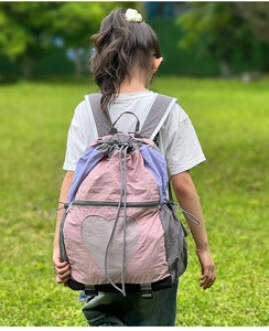 Detail of multi-color drawstring backpack for kids with a heart-shaped mesh pocket
