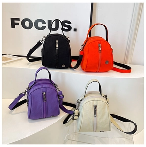Detail showing colorful nylon mini shell bags in black, orange, purple and cream white