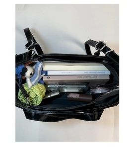 Internal view of black patent leather bucket bag showing large storage capacity