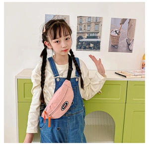 Pink nylon kids chest bag with SPORT patch and orange zipper pull shown on model
