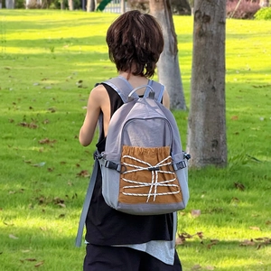 Large gray school backpack with brown front pocket and bungee cord for kids and youth