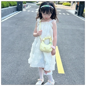 Detail of light yellow pleated cloud bag for kids with pink tulip pendant and strap