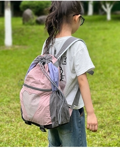 Detailed side view of pink drawstring backpack with heart mesh pocket and toggle system