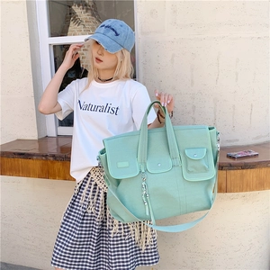 Large mint green canvas tote bag with adjustable shoulder strap and utility pockets