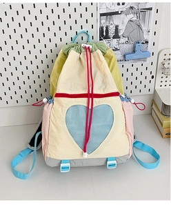 Detail of colorful patchwork backpack with heart mesh pocket and drawstring closure