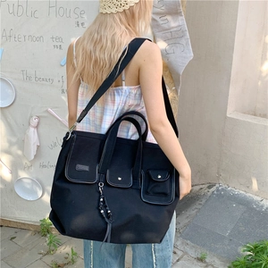 Large black canvas shoulder bag with multiple exterior pockets for casual urban style