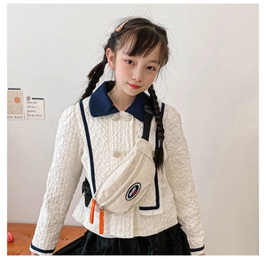 Detail of beige kids chest bag with adjustable strap and orange zipper puller