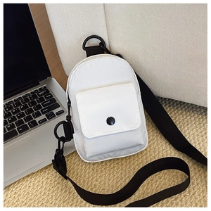 Close-up of a white canvas chest bag with black strap on a soft minimalist background