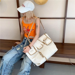 Minimalist canvas tote bag with brown leather trim and multiple pockets for daily commute