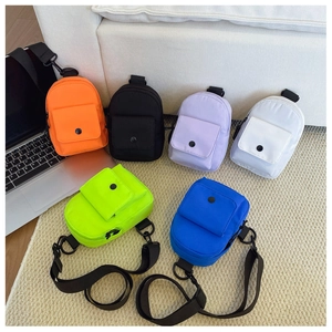 Detailed view of kids chest bags in six colors arranged on a textured rug for display