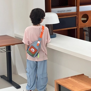 Colorful kids crossbody chest bag in nylon featuring adjustable orange shoulder straps