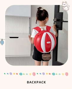 Détail du sac à dos enfant montrant le design ballon 3D aux rayures rouges et blanches