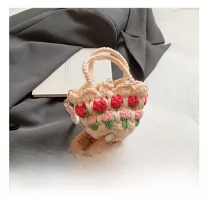 Detailed view of handmade crochet tulip handbag with pearl buckle and green leaves
