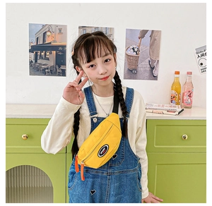 Detailed view of kids yellow nylon chest bag with sport patch worn by a child model