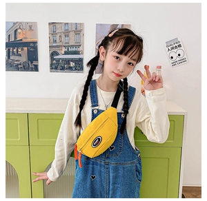 Close-up of bright yellow nylon chest bag for kids with SPORT patch and orange zipper pull