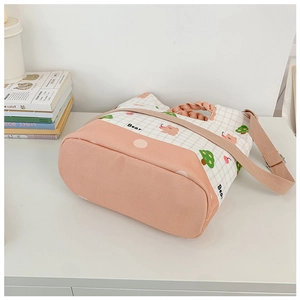 Detail of pink plaid canvas toddler bag featuring cartoon bear print and braided handle