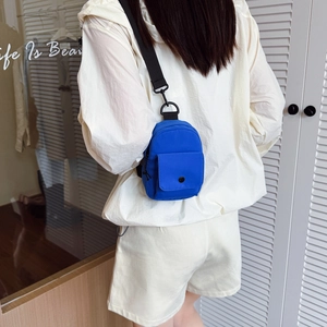 Bright blue mini chest bag for kids with adjustable strap shown from a back view