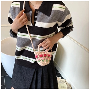 Detailed close-up of handmade crochet tulip shoulder bag with pink knit and red flowers