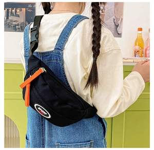Detail of kids black canvas crossbody bag with sport patch and orange zipper strap
