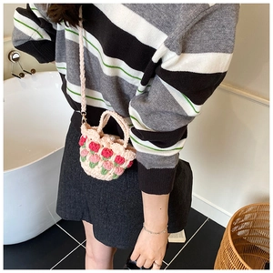 Close-up of handmade crochet mini bag featuring 3D tulip flowers and pearl clasp detail