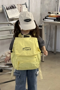 Model wearing a bright yellow large capacity kids backpack with drawstrings
