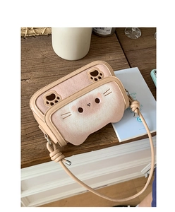 Close-up of pink and beige plush cat purse with embroidery and knot strap details