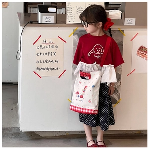 Girl wearing a red ruffled t-shirt with happy print and black polka dot skirt set