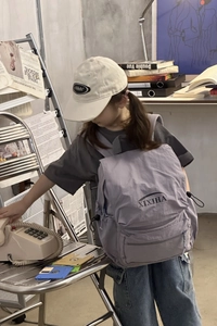 Detail view of purple nylon kid's backpack with side drawstring and brand logo