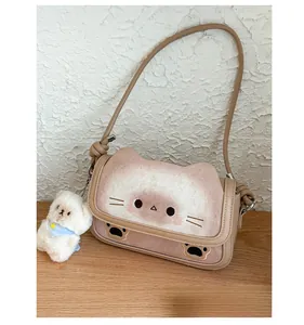Dettaglio della borsa a tracolla con gatto, ciondoli in peluche e materiale scamosciato kaki