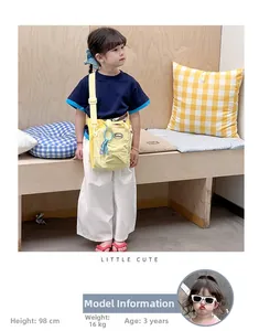Detail of yellow nylon kids crossbody bag with adjustable strap and cute logo detail