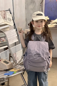 Detail view of a lavender nylon children backpack with side drawstring pockets and logo