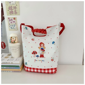 Close-up of canvas kids tote bag with mushroom print and woven red handles