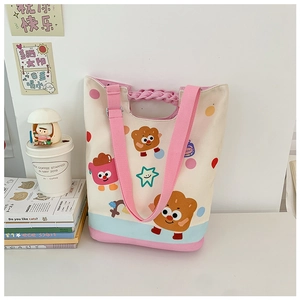 Detail of cartoon canvas tote bag with pink braided handle and plaid pattern accents