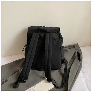 Detailed view of padded shoulder straps and durable fabric texture of the black backpack
