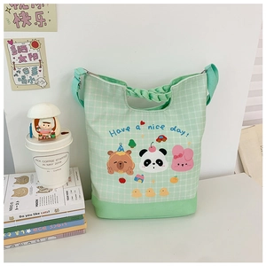 Detail view of mint green plaid canvas tote with cute cartoon animals and adjustable strap
