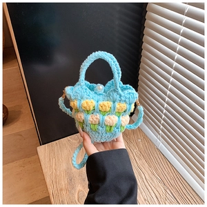 Detail of blue crochet tulip bag featuring 3D floral knit and pearl button closure