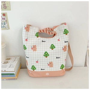Detail of canvas bag featuring pink bear print and braided handle for kids