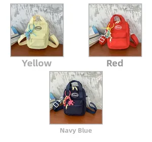 Detailed view of three mini canvas crossbody bags in yellow, red, and navy blue colors