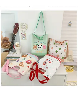 Detail of canvas kids crossbody bag with cartoon panda print and woven handle