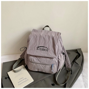 Detail view of light purple nylon kids backpack with front zipper pocket and side drawstring