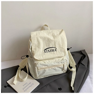 Detail of cream white school backpack with XIXIHA logo and front zipper pocket