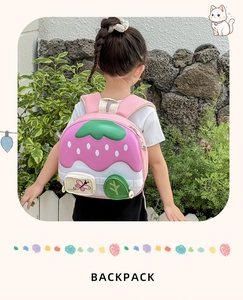 Toddler backpack featuring strawberry house design worn by child in outdoor setting
