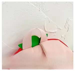 Detail view of the pink strawberry-themed handle on a cute cartoon kids backpack