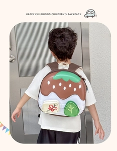 Detail of cute strawberry cake toddler backpack shown on a child in a home setting